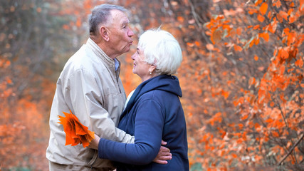 Elderly man kisses the woman's forehead