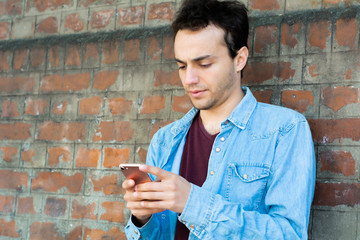Young man typing on his phone.