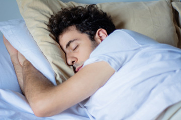 Fototapeta na wymiar Man sleeping in bed