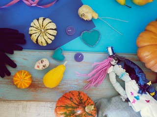 Decorative composition of pumpkins, pears, magic dolls and felt hearts on a wooden table, top view, Halloween, preparation for home seasonal holiday