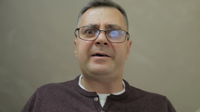 Close-up of middle-aged men, which stoops down and yells and screams gesticulating.