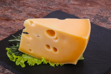 Maasdam cheese  in the board served salad leaves
