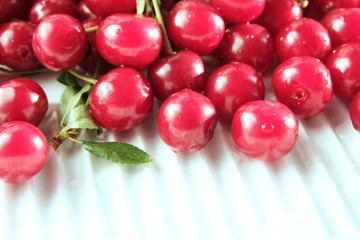 Close up of pile of ripe cherries with stalks and leaves. Large collection of fresh red cherries. Ripe cherries background.