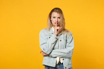 Portrait of secret young woman in denim casual clothes say hush be quiet with finger on lips shhh...