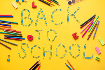 Various school accessories on yellow board with text Back to school. Concept back to school.