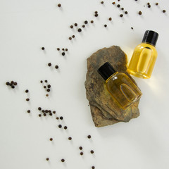Bottles with black peper essential oil. Natural healthy cosmetic treatment products.