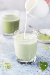 Obraz na płótnie Canvas Iced Matcha green latte in glasses with matcha powder on light background.