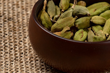 Cardamom in a ceramic cup on a canvas background