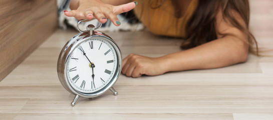 Sleepy young woman trying kill alarm clock . Early wake up, not getting enough sleep, getting work...