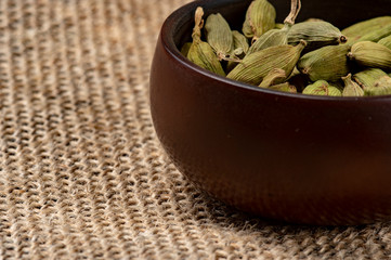 Cardamom in a ceramic cup on a canvas background