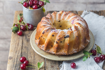 Fresh homemade bundt cake with cherry on wooden table