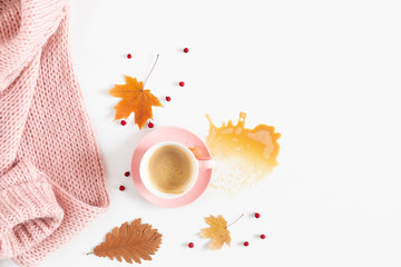 Autumn cozy composition. Dry yellow  leaves, cup of coffee, pink knitted sweater on white background. Fall concept. Autumn background. Flat lay, top view, copy space