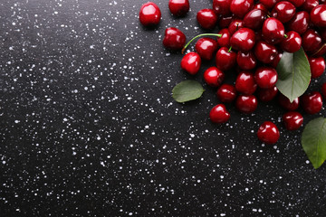 Bunch of fresh organic sweet cherries on textured background. Clean eating concept. Healthy nutritious vegan snack, raw diet. Close up, copy space, top view, flat lay.