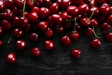 Bunch of fresh organic sweet cherries on textured background. Clean eating concept. Healthy nutritious vegan snack, raw diet. Close up, copy space, top view, flat lay.