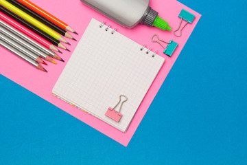 Stationery. School and office supplies on a blue and pink colored background. Selective focus.Advertising space