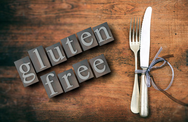 Gluten-free text and cutlery on rustic wooden table, top view. 3d illustration