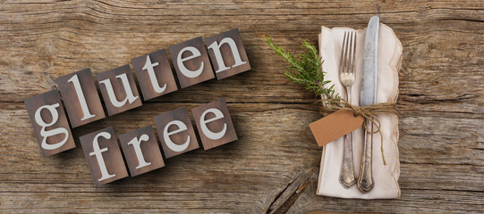 Gluten-free text and cutlery on rustic wooden table, top view. 3d illustration