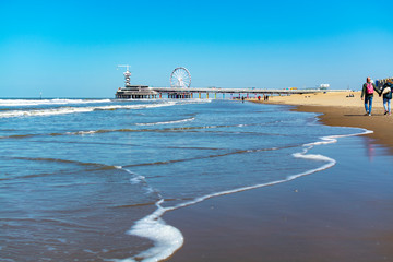 People walking in sunny day on North sea beach in Netherlands near Scheveningen