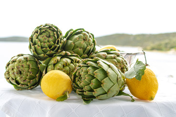 Obraz premium Bunch of fresh raw artichokes heads from artichoke plantation in Argolida, Greece ready to cook with lemon