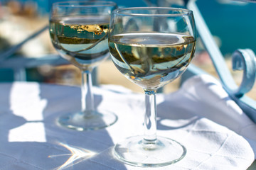 White wine served outside on balcony on glass table with sea view
