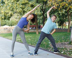 Mother and son stretching outdoors