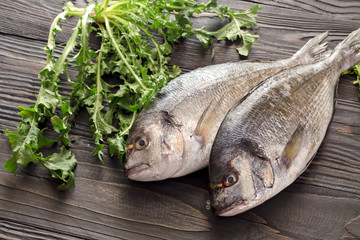 Raw gilthead (Sparus aurata) on a wooden table