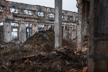 Ruins of industrial enterprise, dark debris destroyed factory premises in factory as result of economic crisis and earthquake.