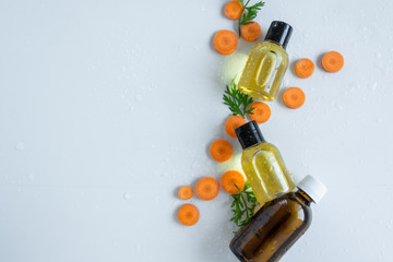 Top view of bottles with carrot essential oil. Healthy cosmetic product.