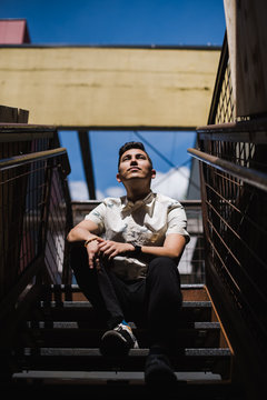Thoughtful young man sitting on staircase outdoors