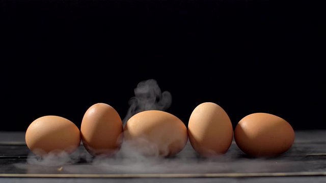 Smoker in slow motion on black background and eggs
