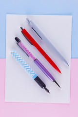 Back to school pop art concept. School stationery on pink blue background. Multicolored pens on pastel background. Flat lay. Copy space