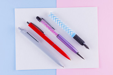 Back to school pop art concept. School stationery on pink blue background. Multicolored pens on pastel background. Flat lay. Copy space