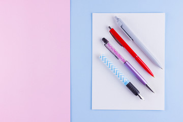 Back to school pop art concept. School stationery on pink blue background. Multicolored pens on pastel background. Flat lay. Copy space