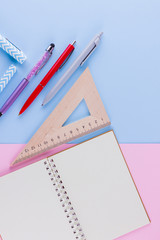 Back to school pop art concept. School stationery and seashell on pink blue background. Pens, pencil and gon on pastel background. Top view. Copy space