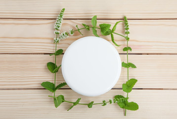 jar of cream with sprigs of fresh mint on a wooden background. Top view