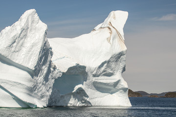 Huge iceberg with a stripe layer of sediment. Off the coast of Twillingate Newfoundland, Iceberg Alley.  