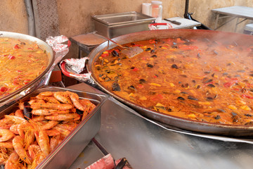 Street food, large pan of paella seafood cooking on market in Provence