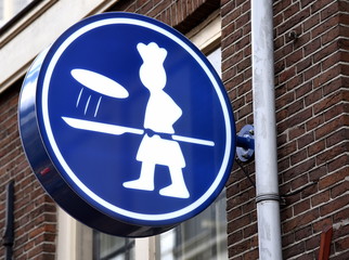 Hinweiszeichen: Pizzabäcker an einer Backsteinfassade von Amsterdam 
