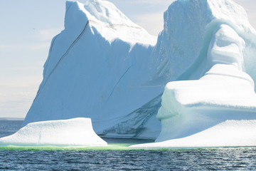 Close up of a large iceberg  with a stripe of sediment making its way down 'Iceberg Alley' off the coast of Twillingate Newfoundland. 