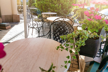 Fototapeta na wymiar Cozy terrace on an italian street with white chairs and white flowers
