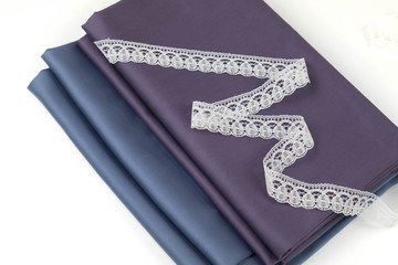 Two cuts of natural cotton fabric of dark tones blue and claret. Fabric is put in the form of a...