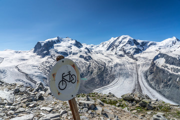 Cycling not allowed, Sign post on the Gornergrat with spectacular view at Monte Rosa  and Gorner...