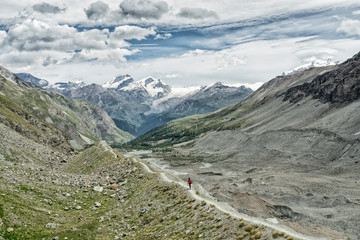 young woman, hiking on the moraine above Zmutt glacier near Zermatt, Cantone Valais, Wallis,...