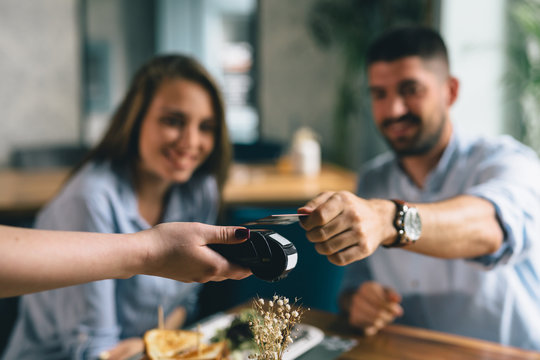 man making payment with smartphone in restaurant