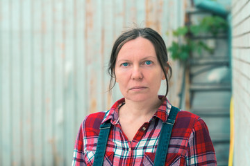 Portrait of beautiful female farmer in front of farmhouse shed