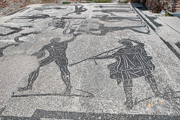 Ancient Roman art with the mosaic depicting athletes and  trumpeter in the frigidarium of the thermal baths of Porta Marina located in the archaeological excavations of Ostia Antica - Rome