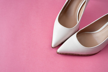 Light white high heels isolated on a bright pink pastel background. Fashion concept