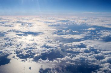 View from plane window. Clouds above water surface. Atmosphere concept. Air pollution. Greenhouse effect. Cloudy day weather forecast. Travel by air. Freedom and stunning beauty. High in air