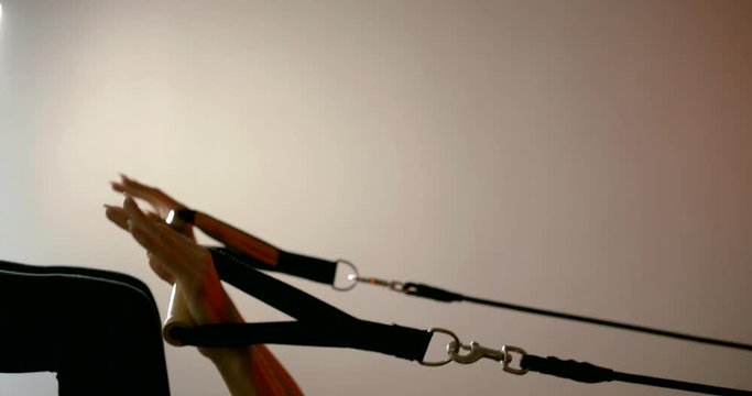 Close-up of the girl's body, Pilates simulator with ropes, hooks and springs.