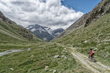 Fototapeta na wymiar nice and ever young senior woman riding her electric mountainbike up to the Taeschalp, near Zermatt, Cantone Valais, Wallis, Switzerland
